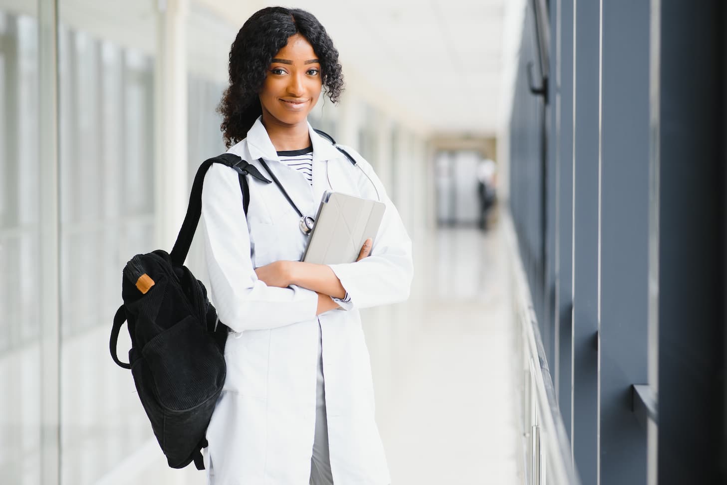 Young black female doctor with a backpack and clipboard