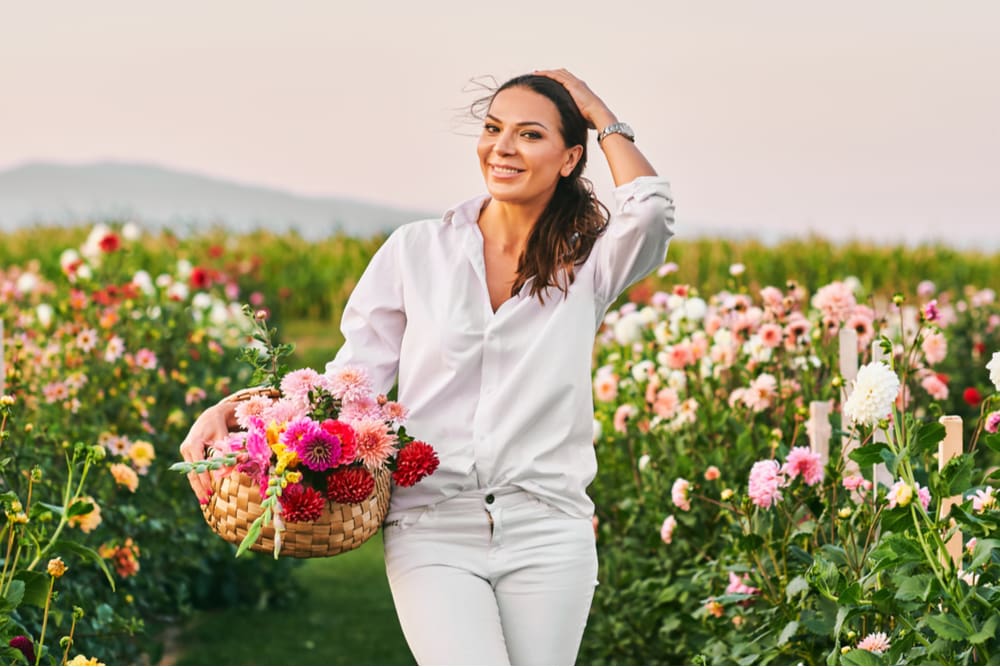 Pretty woman collecting flowers in a huge field