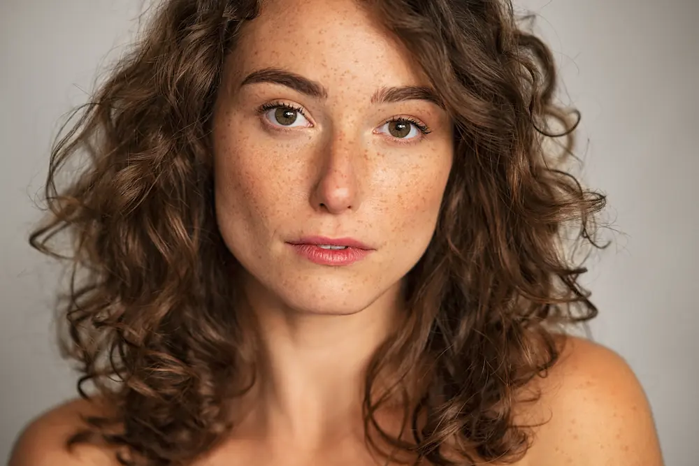 Curly hair model with freckles and clear skin